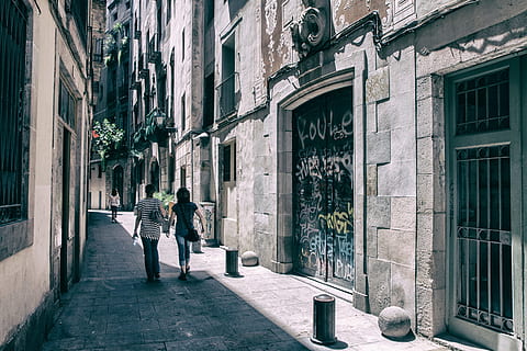 A couple of people walk through the streets of the Gothic Quarter in Barcelona, Spain HD wallpaper