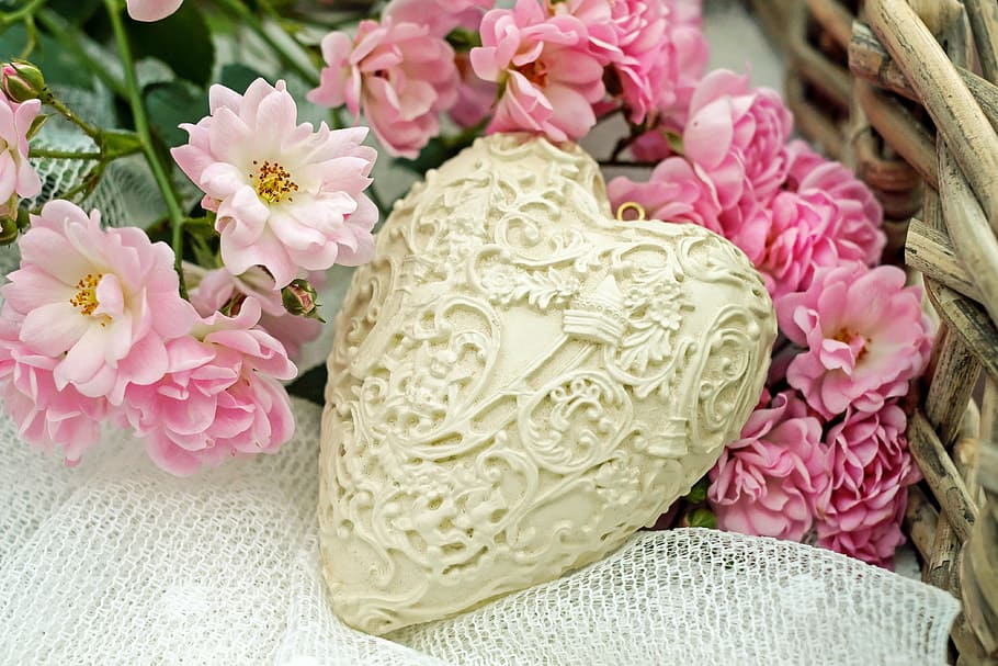 heart-shaped white container on top of white surface and pink petaled flowers HD wallpaper