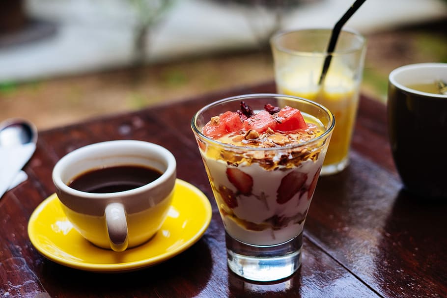 dessert serve in clear glass cup, white ceramic mug beside clear glass on brown wooden table HD wallpaper