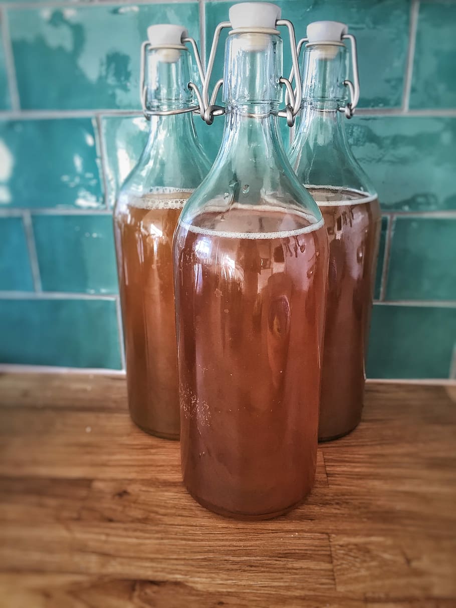 three clear glass bottles filled with brown liquids, Kombucha HD wallpaper
