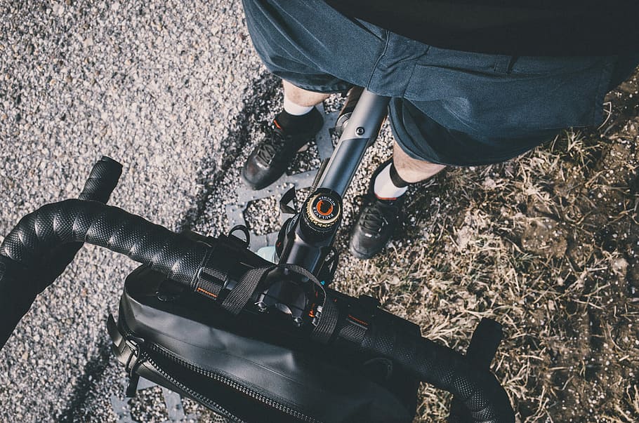 shallow focus photography of black bicycle handlebar, person riding road bicycle HD wallpaper