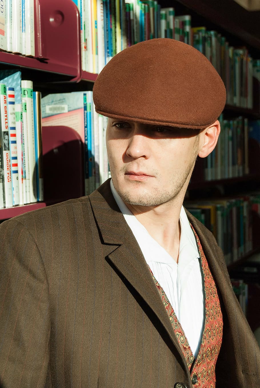 man leaning on wooden bookshelf, library, cap, model, graduation HD wallpaper