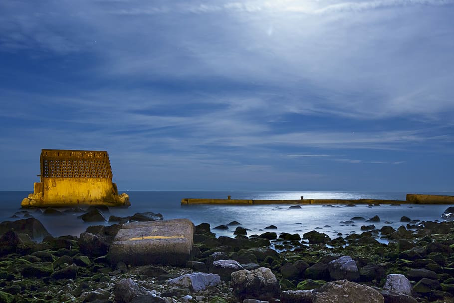 body of water under clear sky, rocky shore photo, blue sky, clouds HD wallpaper