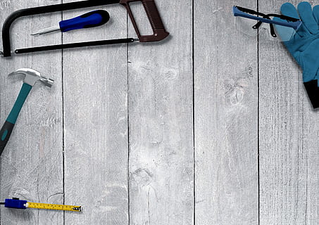 black framed safety glasses, black hacksaw, gray claw hammer, and yellow measuring tape on top of gray board HD wallpaper