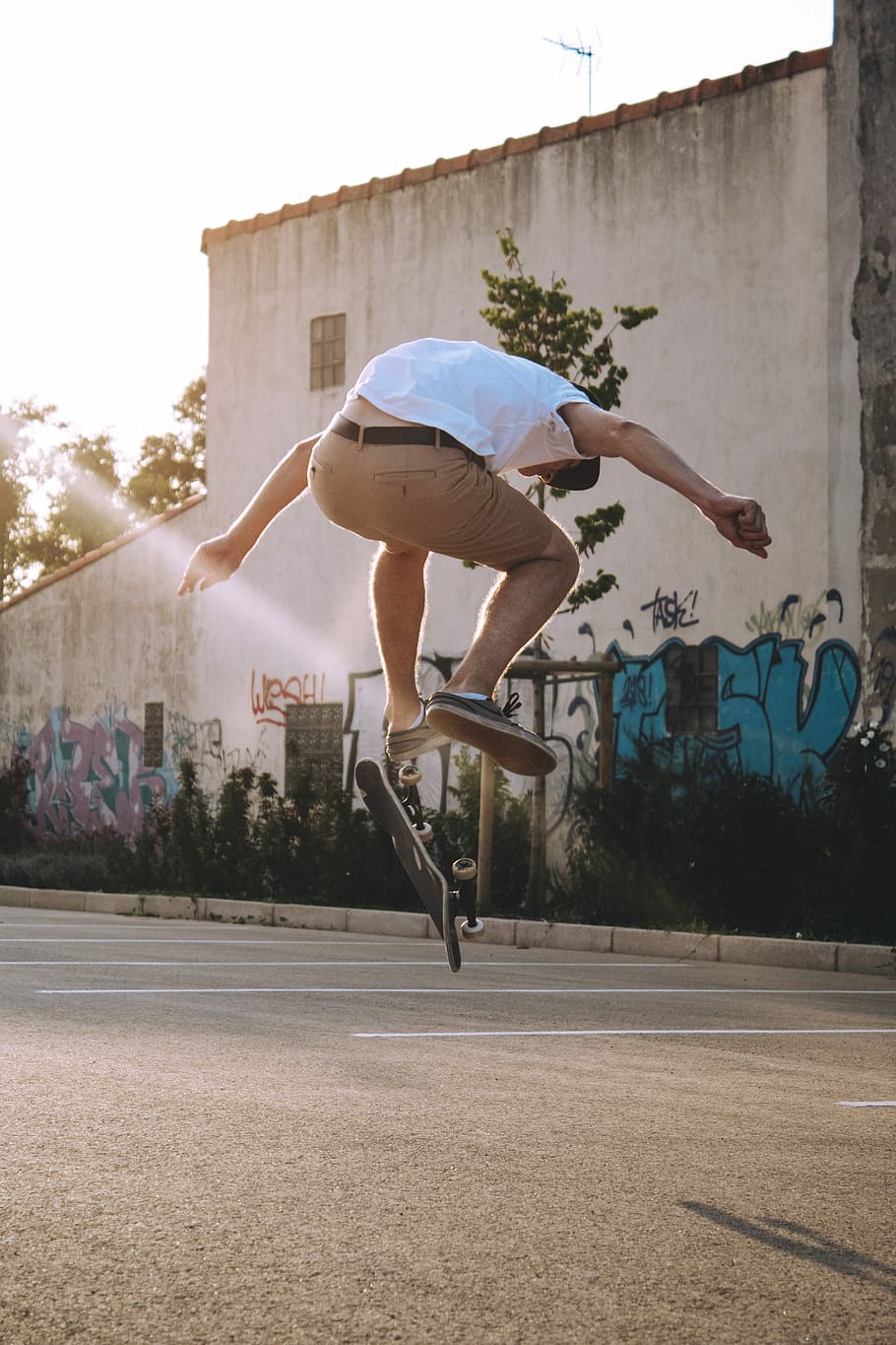 man playing long board wearing white shirt, man jumping with skateboard time lapse photography