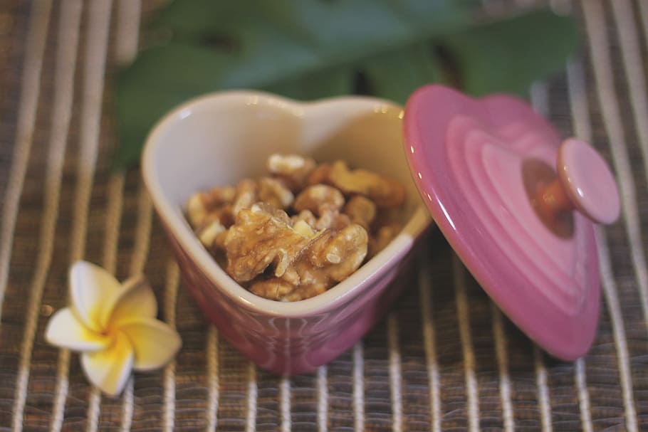 selective focus photography of nuts on heart-shape pink ceramic container HD wallpaper