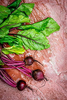 focus photo of green vegetable, red onions on red table surface HD wallpaper