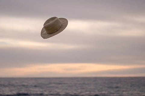 hat flying above the ocean during day time, sun hat toss on air HD wallpaper