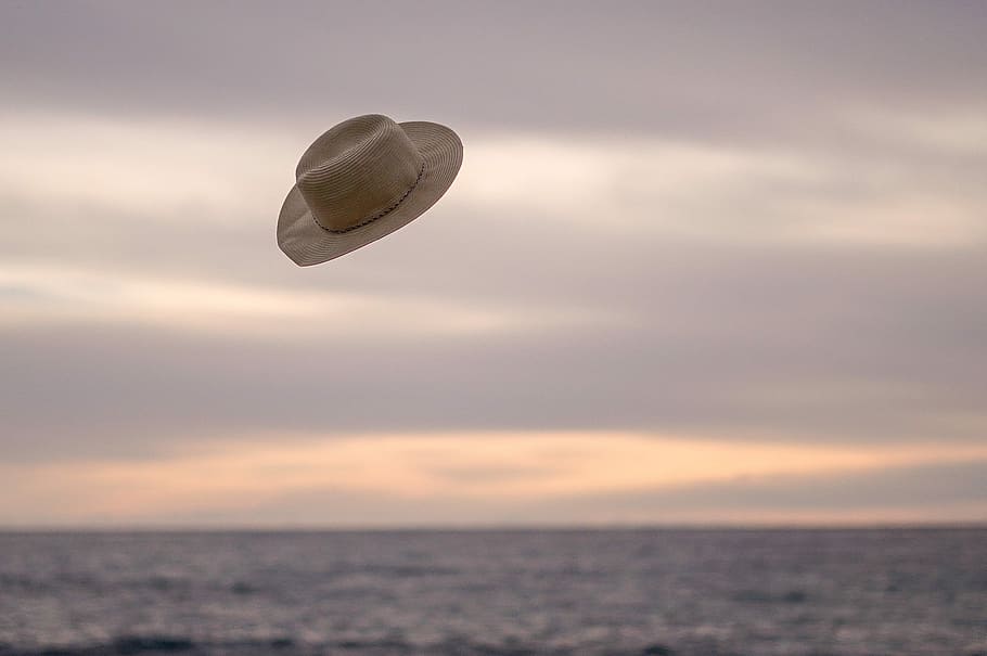 hat flying above the ocean during day time, sun hat toss on air, HD wallpaper