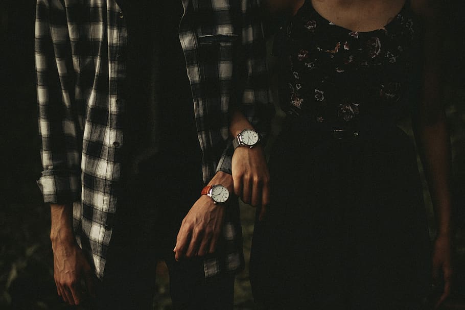 man and woman standing while holding hands, man and woman with matching pairs of watches HD wallpaper