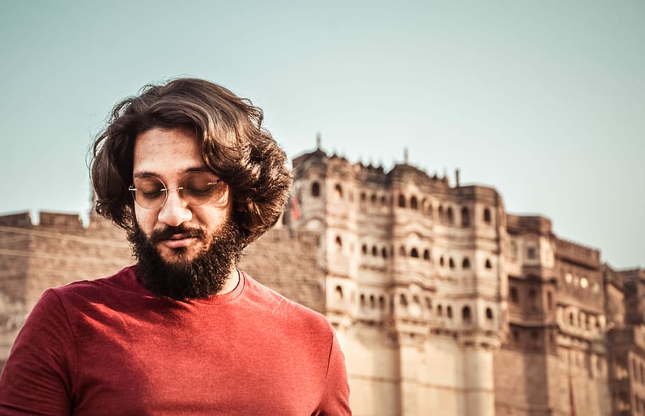 man wearing red crew-neck shirt standing near the ancient palace, man wearing red shirt at daytime HD wallpaper