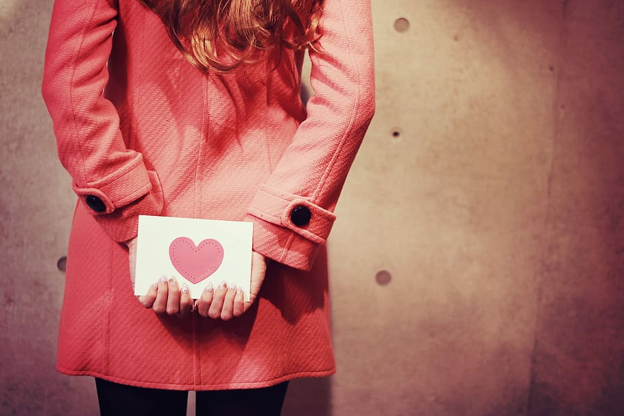 woman wearing pink coat holding back her love letter card, heart Shape HD wallpaper