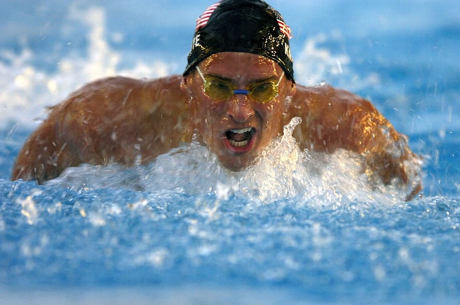 man wearing goggles while swimming on pool, swimmer, butterfly