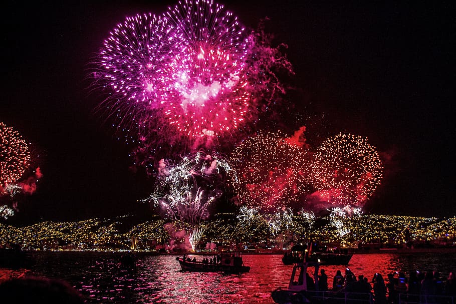 fire works festival at night, fireworks display near body of water