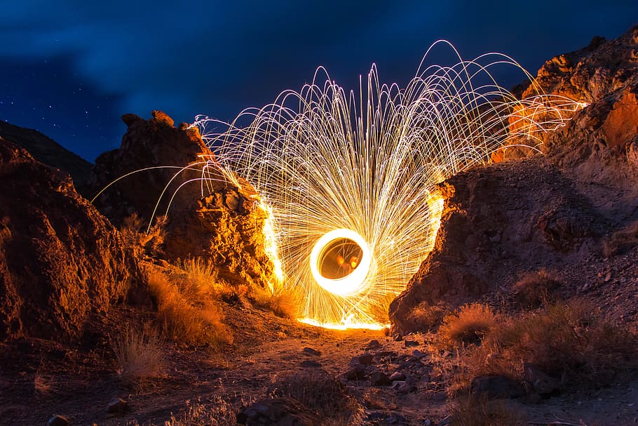 steel wool photography in between rocks, fireworks, night, celebration HD wallpaper