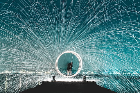 man standing on dock steel wool photography, steel wool photography of man on wooden dock between body of water HD wallpaper