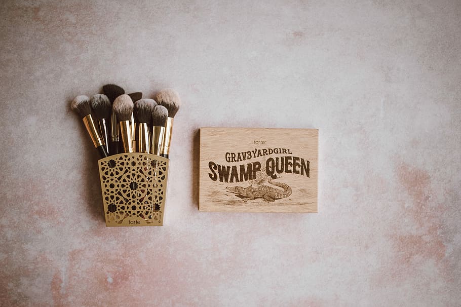 Tarte make up, brown make-up brush set on brown steel rack beside Swamp Queen makeup palette HD wallpaper