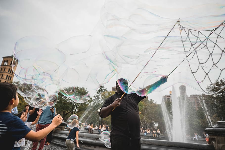 man and boy performing bubble artworks near fountain at daytime, people plying bubbles HD wallpaper