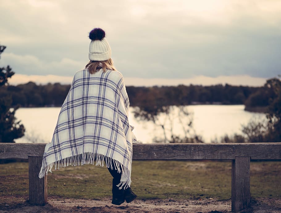 woman sitting on gray wooden bench viewing body of water, person sitting on brown wooden bench nearby calm body of water HD wallpaper