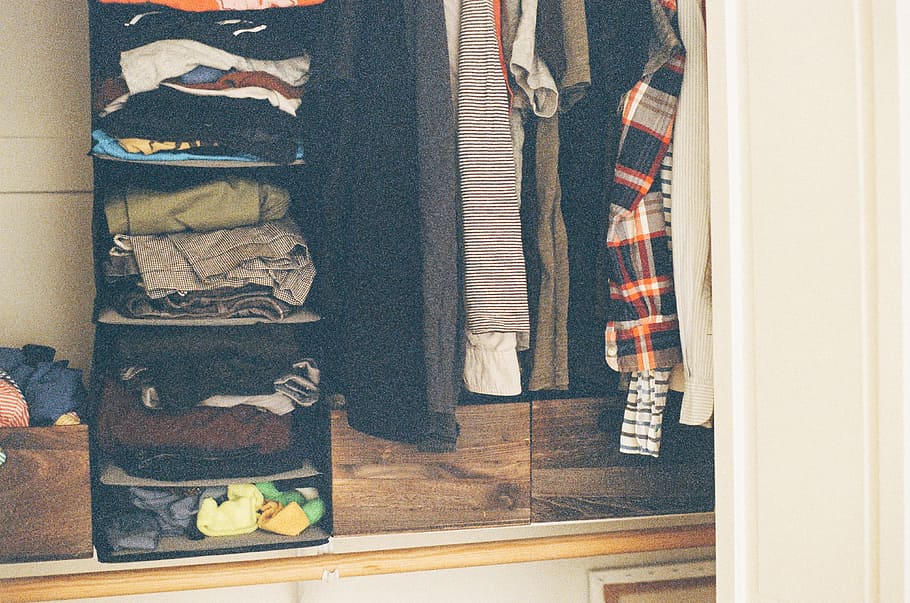 assorted-color clothes lot, closet, shirts, pants, indoors, no people