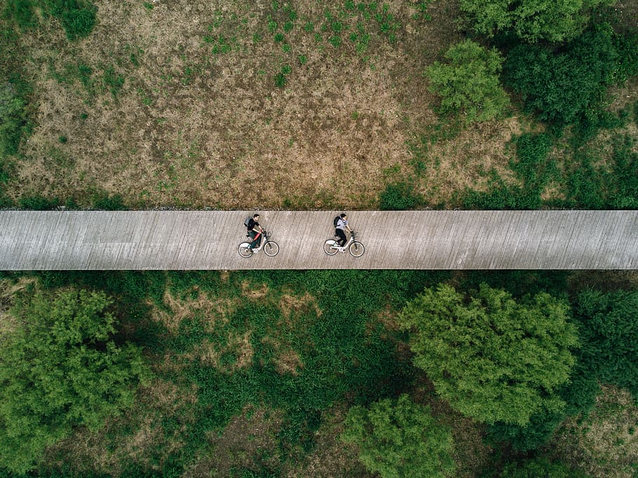 aerial view photography of two person on road, two people riding bike on bridge HD wallpaper