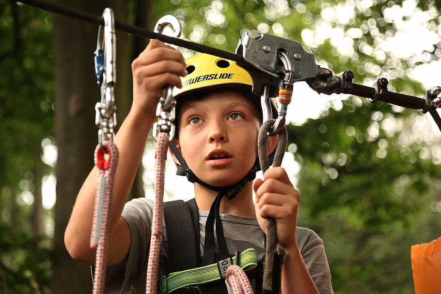 boy wears white cycling helmet and holds ropes, climbing, climber