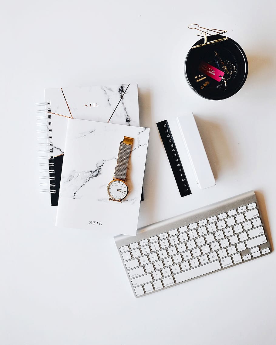 Apple Magic Keyboard near round gold-colored analog watch with silver-colored mesh band with notebook on white surface photography, Apple Magic keyboard near round gold-colored wristwatch on white surface HD wallpaper