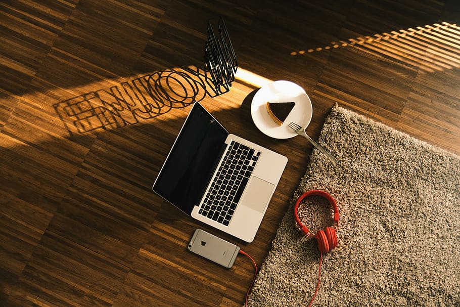 turned off MacBook Pro besides headphones iPhone and slice cake, MacBook Pro beside sliced cake on plate with headphones and phone placed on floor HD wallpaper