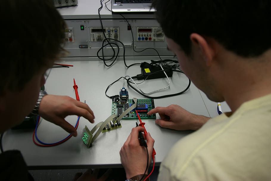 man in white top holding multimeter, training, measurement technology HD wallpaper