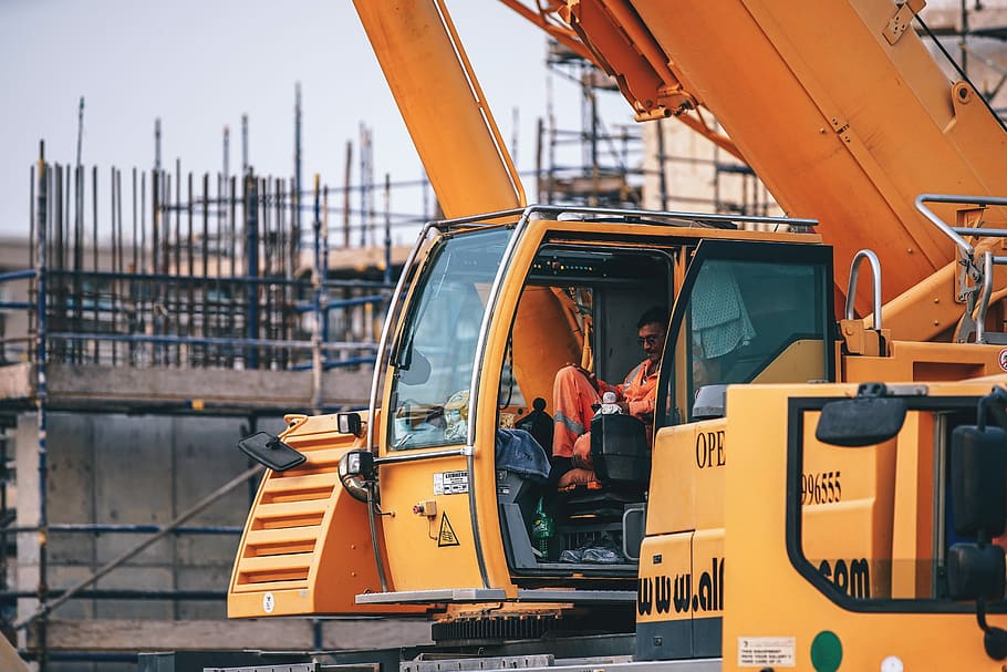 Construction Worker, man riding yellow tractor, crane, digger