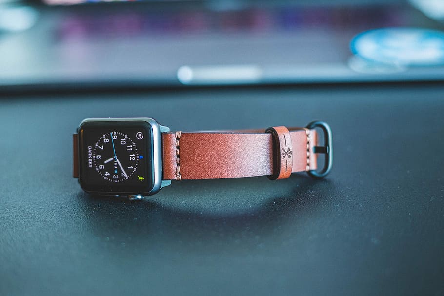 Apple watch leather band, photo of space gray aluminum case Apple Watch with brown leather strap on black surface