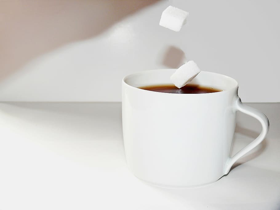 white ceramic teacup filled with black liquid and sugar cube HD wallpaper