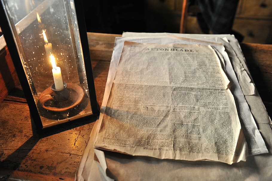 book page on table near candle, newspaper, printing, burning HD wallpaper