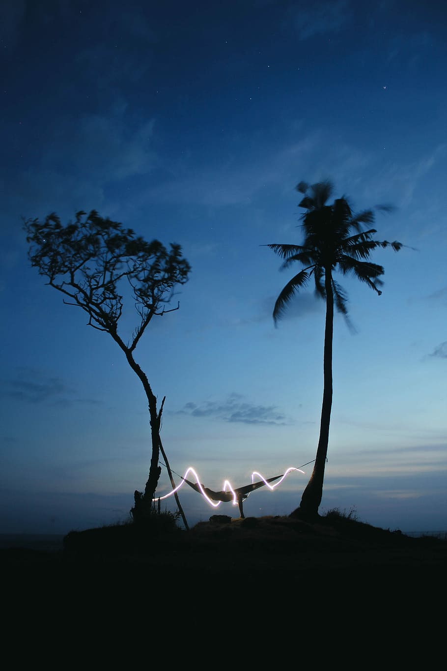 hammock hanged between trees with LED strip light at night HD wallpaper