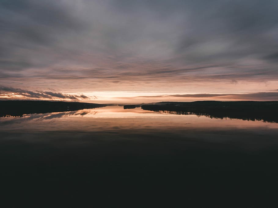 dock reflecting on body of water, lake under gray cloudy sky at golden hour HD wallpaper