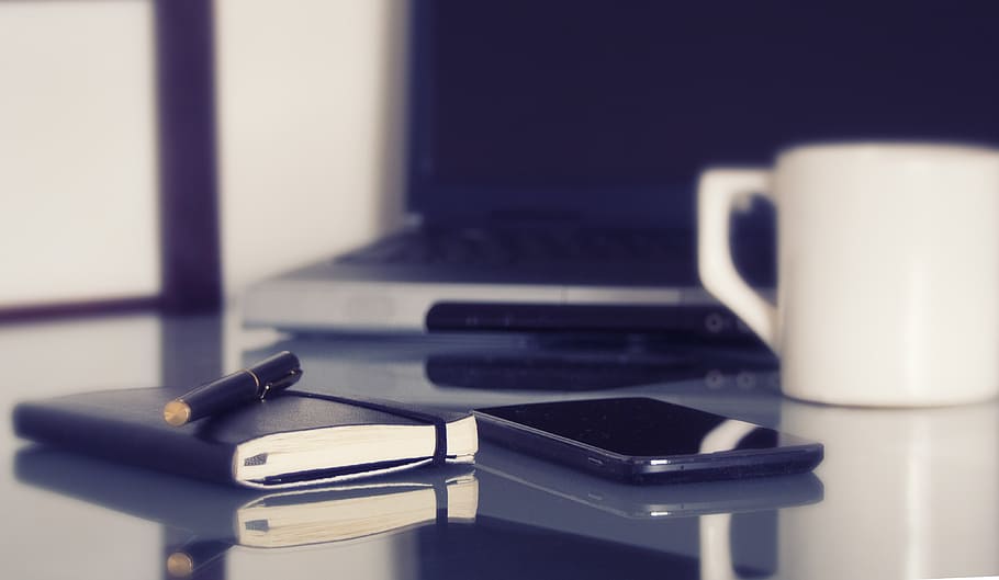 black smartphone between notebook and white ceramic mug, computer HD wallpaper