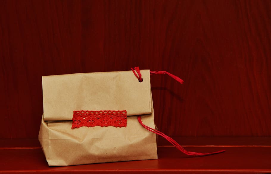 beige paper bag on red surface, made, gift, packed, packaging HD wallpaper