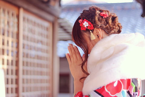 shallow focus photography of woman offering prayer on a temple during day time HD wallpaper