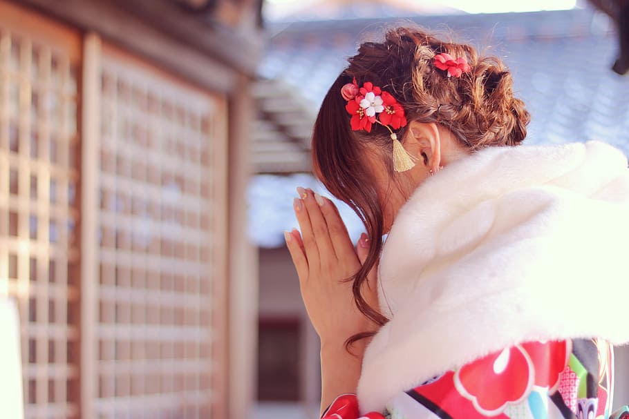 shallow focus photography of woman offering prayer on a temple during day time HD wallpaper