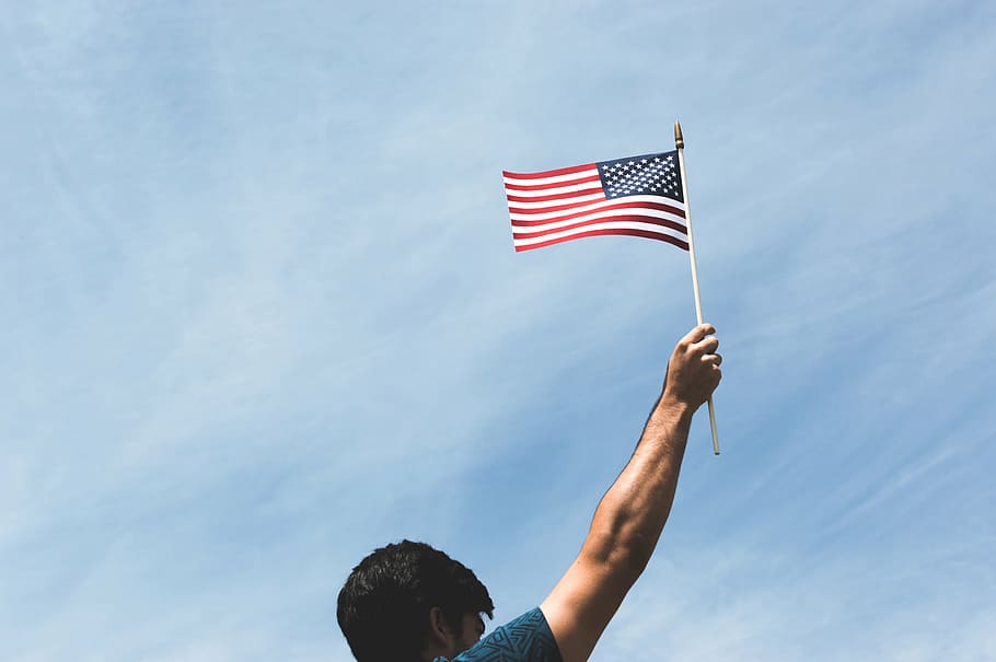 man holding US flag during daytime, american, patriot, united states