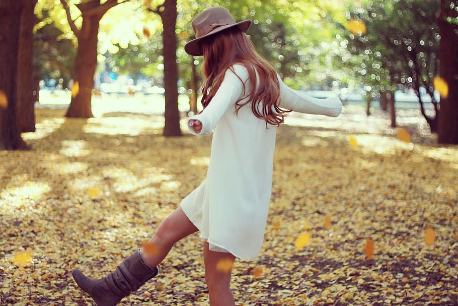person wearing yellow cardigan and fedora hat and enjoying the brown fallen leaves during  daytime HD wallpaper