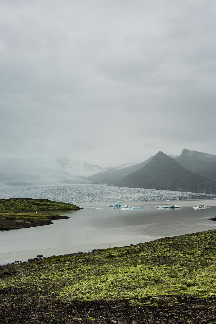 body of water surrounded gray mountains photography, aerial photography of mountains and lake under white clouds at daytime HD wallpaper