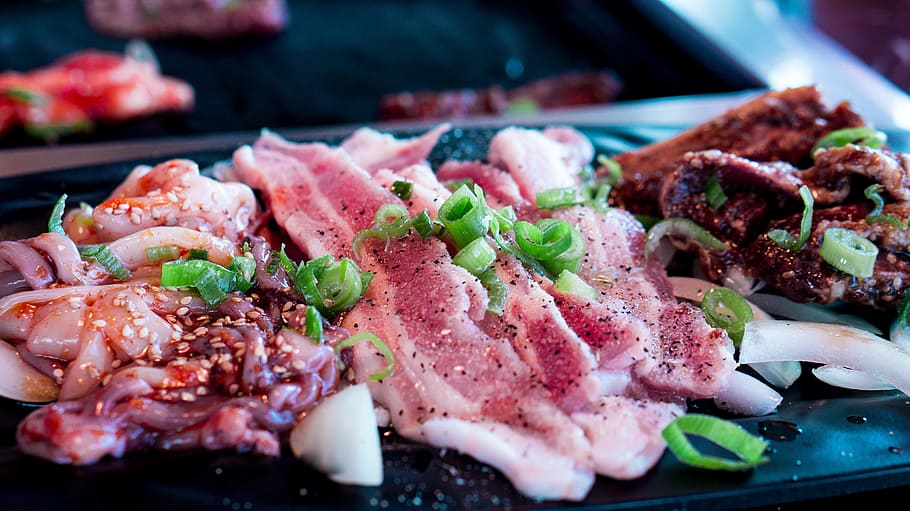 raw meat and octopus tentacles on black surface, barbecue, korean bbq
