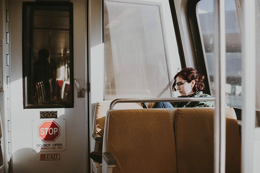 woman sitting in train, woman sitting on chair, subway, sun, commute HD wallpaper