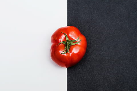 red heirloon tomato on white and black surface, fruit, vegetable HD wallpaper