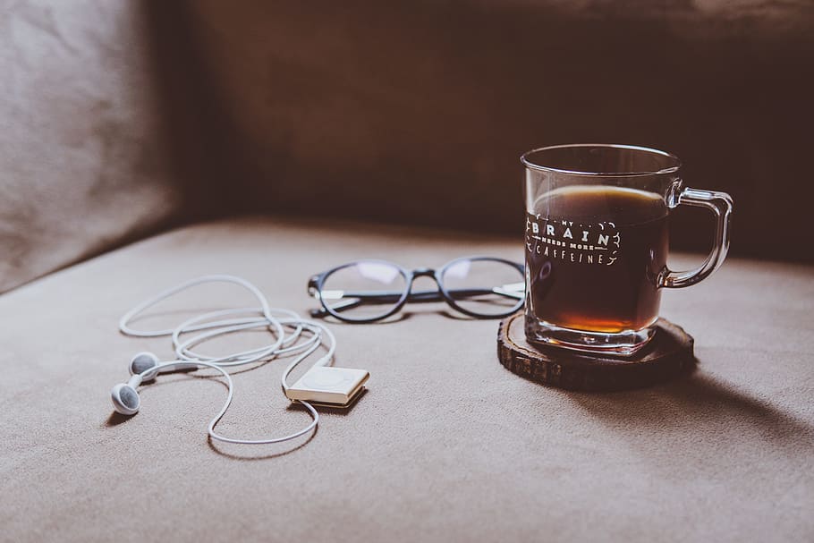 clear Brain printed glass mug on brown wood slab coaster beside black framed eyeglasses and white earphones, clear glass cup, HD wallpaper