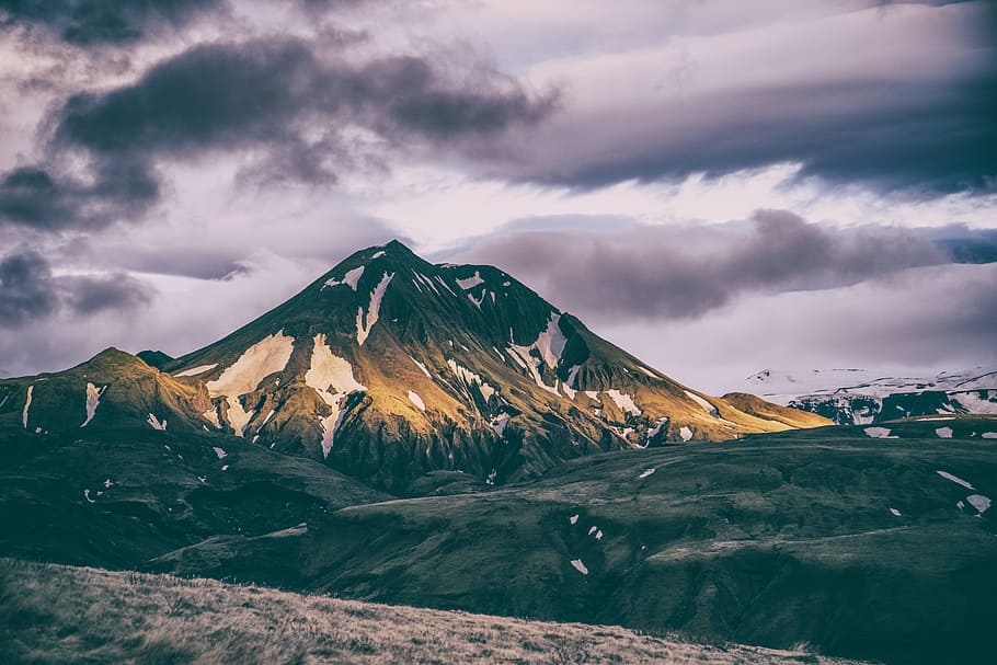 mountain coated with snow during daytime, green and brown mountain under gray clouds during daytime HD wallpaper