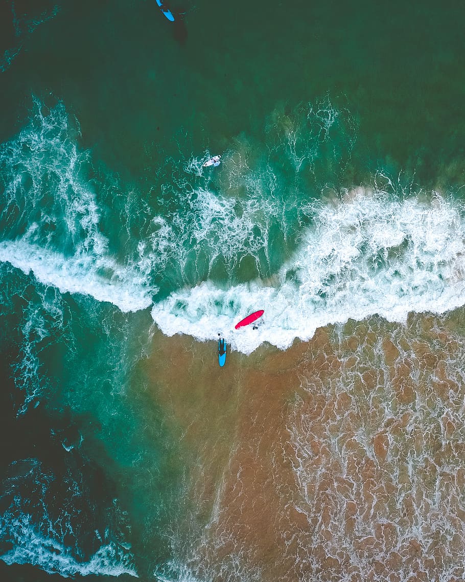 person riding on surfboard while surfing, aerial view photography of green body of water HD wallpaper