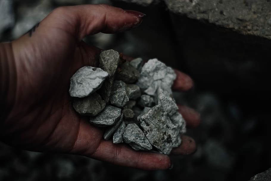 person holding gravel stones, person grabbing gray stone fragments HD wallpaper