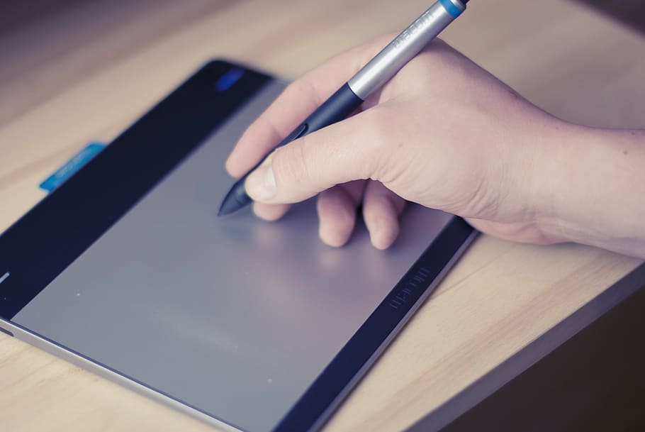 person holding graphics pen, stylus, point, black, grey, wacom